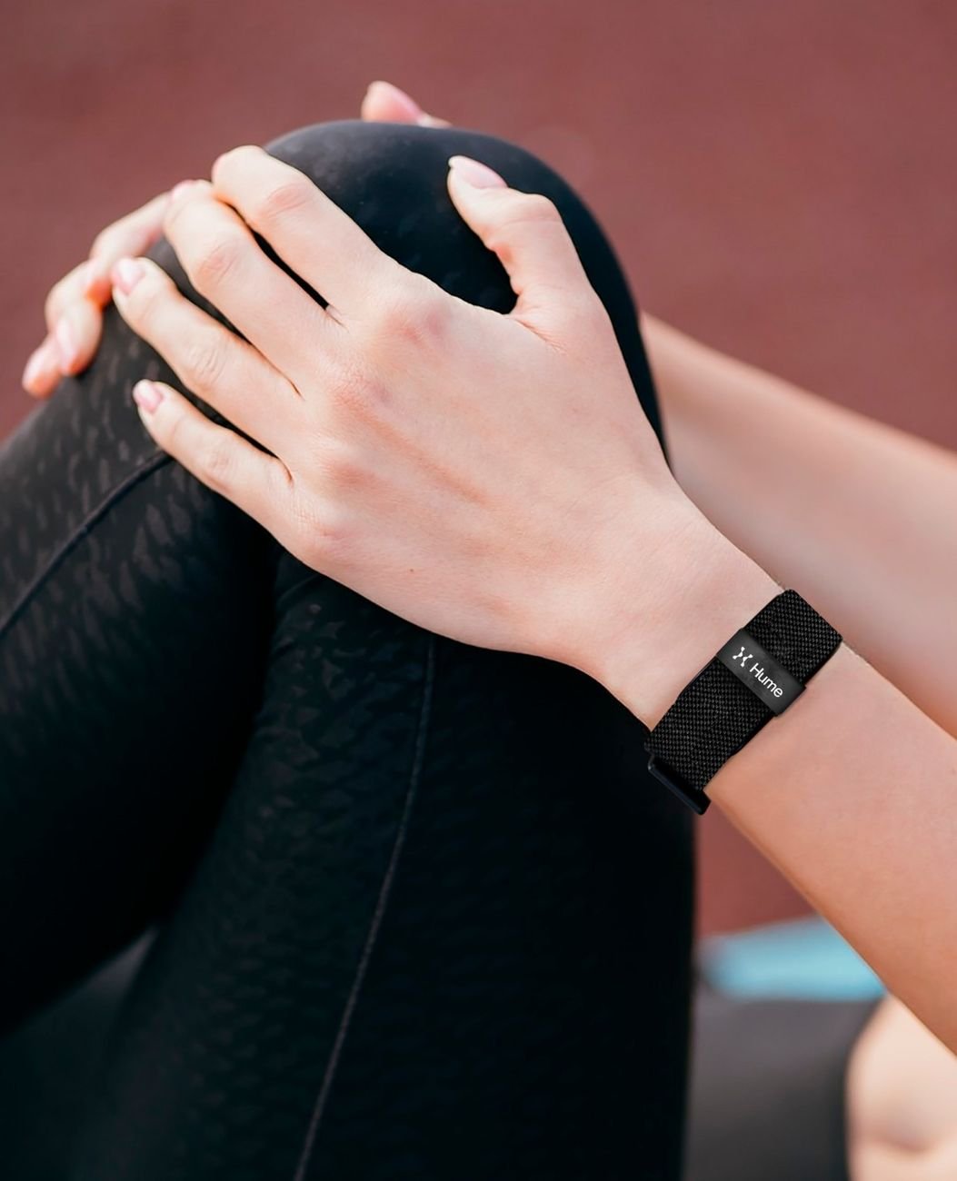 Close-up of hands with the Human Band on the wrist during a stretching routine